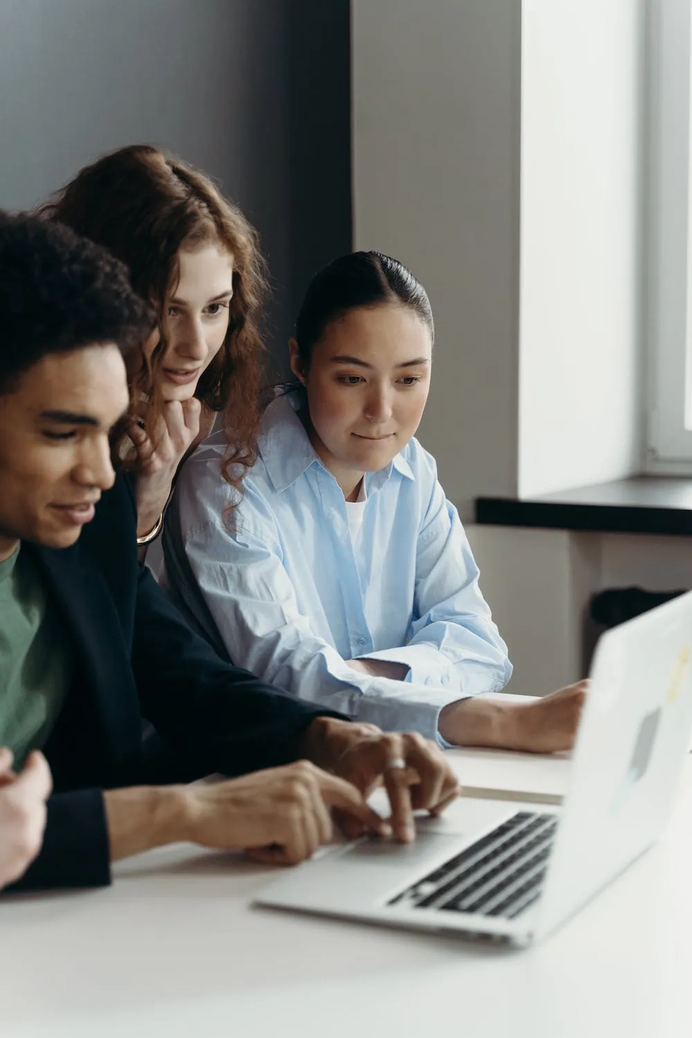 three people collaborating at laptop